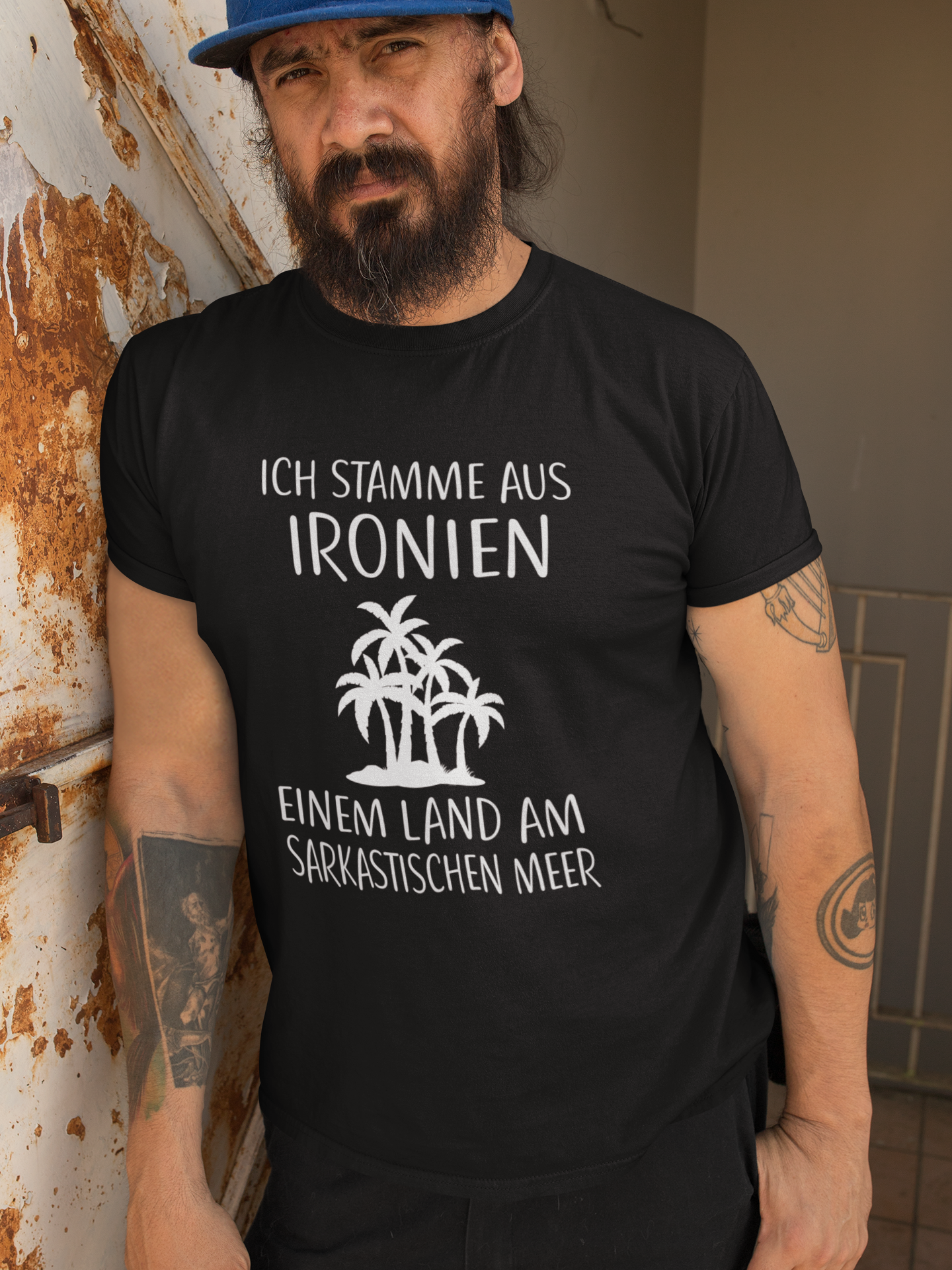 Mann trägt schwarzes Shirt mit ironischem Spruch „Ich stamme aus Ironien…“ (Oberkörper)