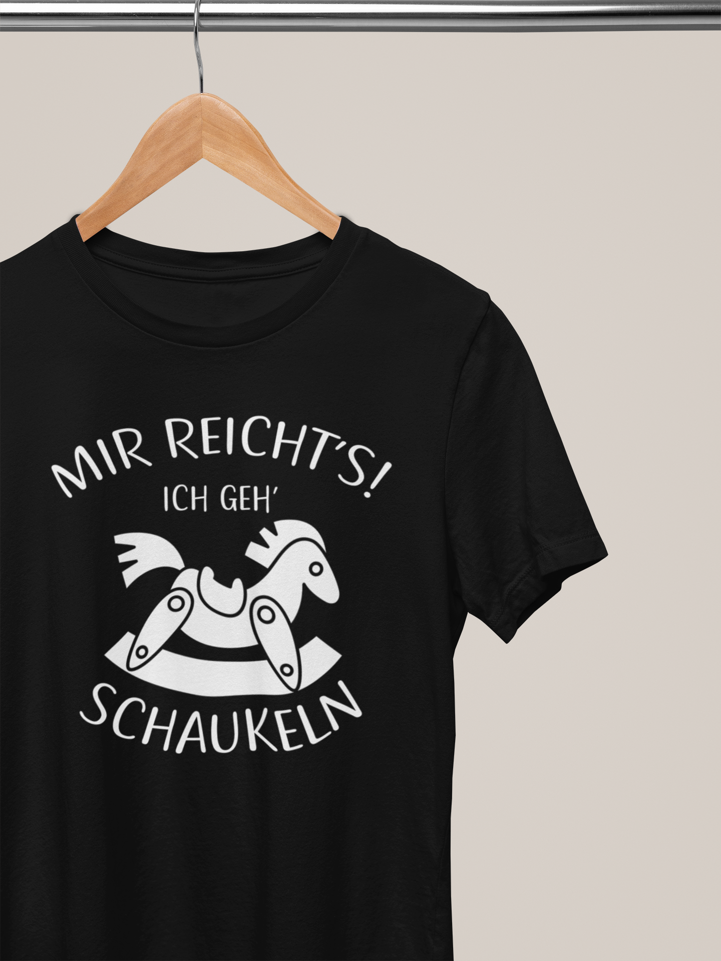 Schwarzes T-Shirt mit weißem Spruch „Mir reicht’s! Ich geh’ schaukeln.“ und einem trotzig schaukelnden Pferd auf Kleiderbügel