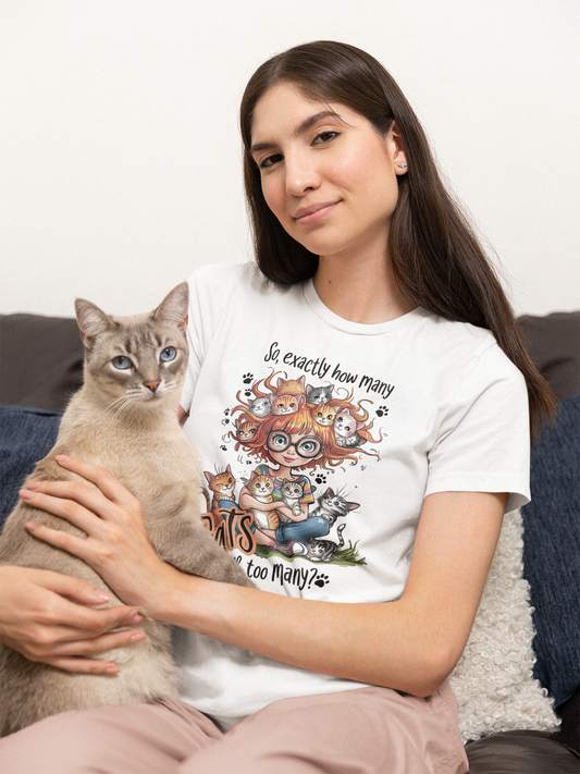 Frau mit grauer Katze. Sie hat lange schwarze Haare und trägt ein Shirt mit Comic-Katze-Motiv.