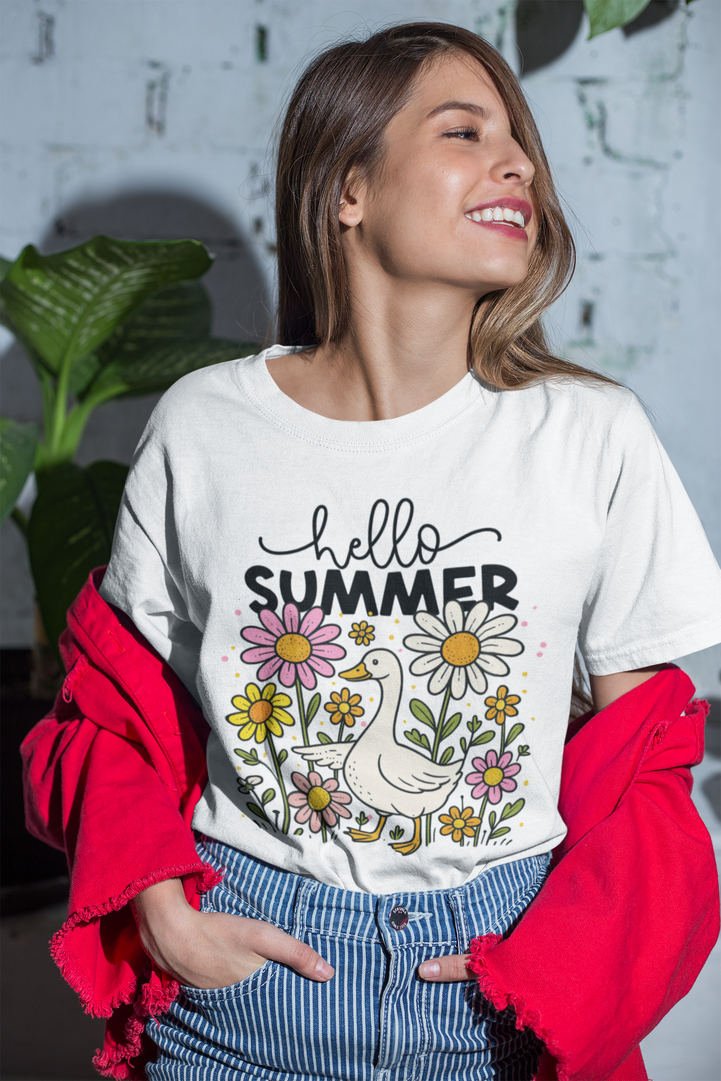Frau steht, lacht und trägt ein weißes T-Shirt mit Gans-Motiv zwischen Blumen und dem Schriftzug „Hello Summer“