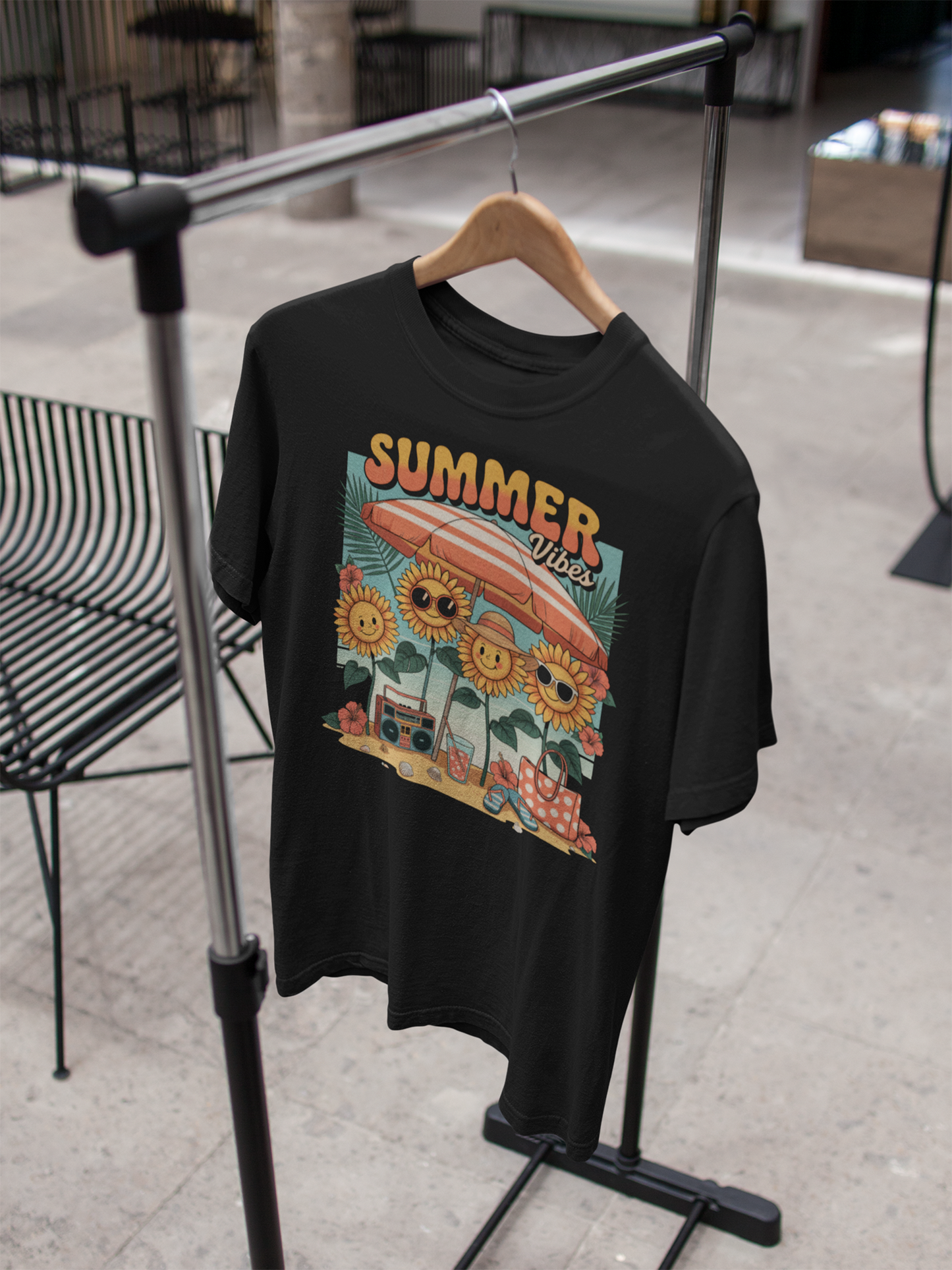 Schwarzes T-Shirt mit bunten Blumen und Aufschrift "Summer Vibes" hängt an einem Kleiderständer.