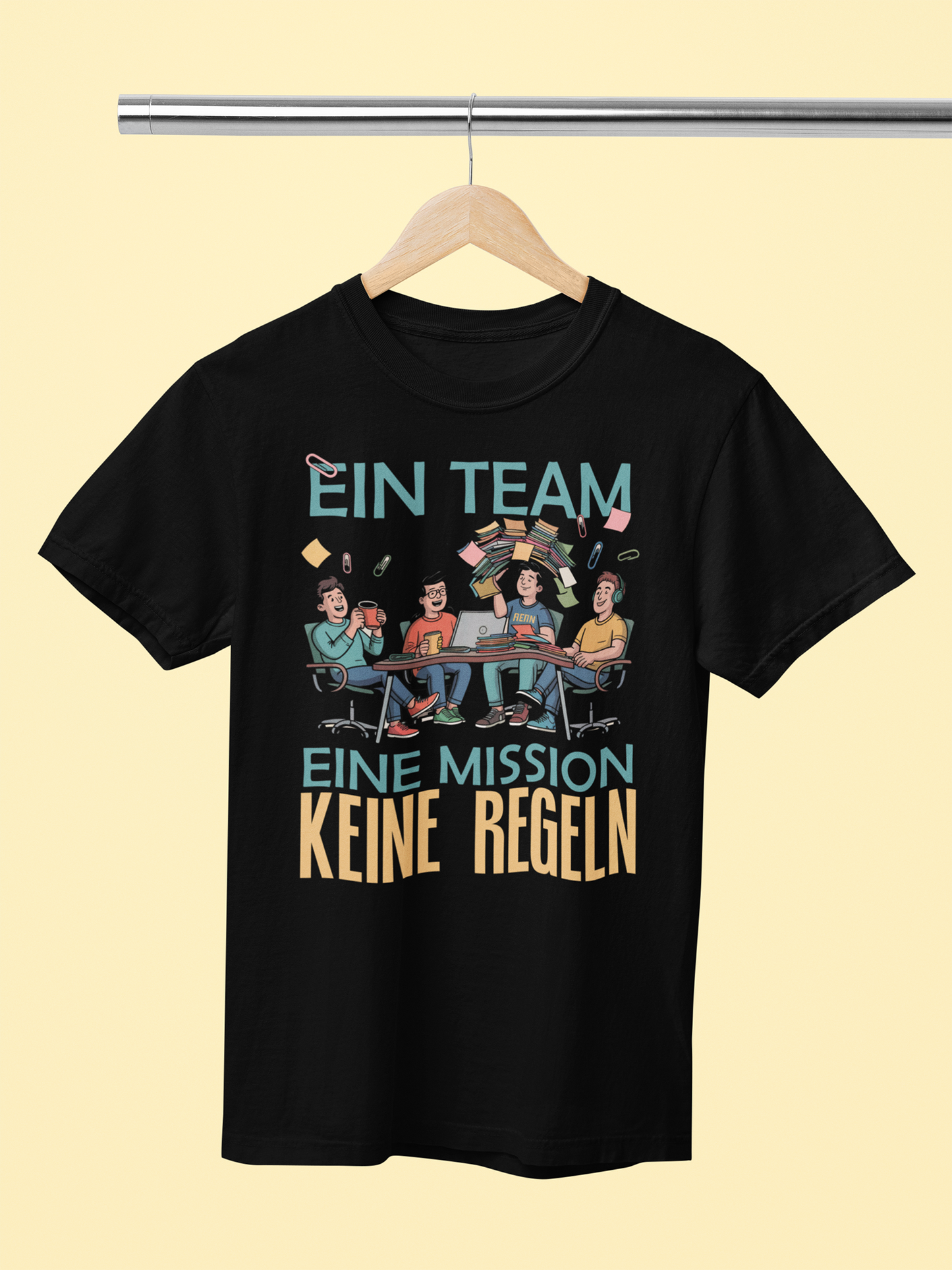 Schwarzes T-Shirt auf Holszkleiderbügel mit Text: „Ein Team. Eine Mission. Keine Regeln.“ und comic Bild