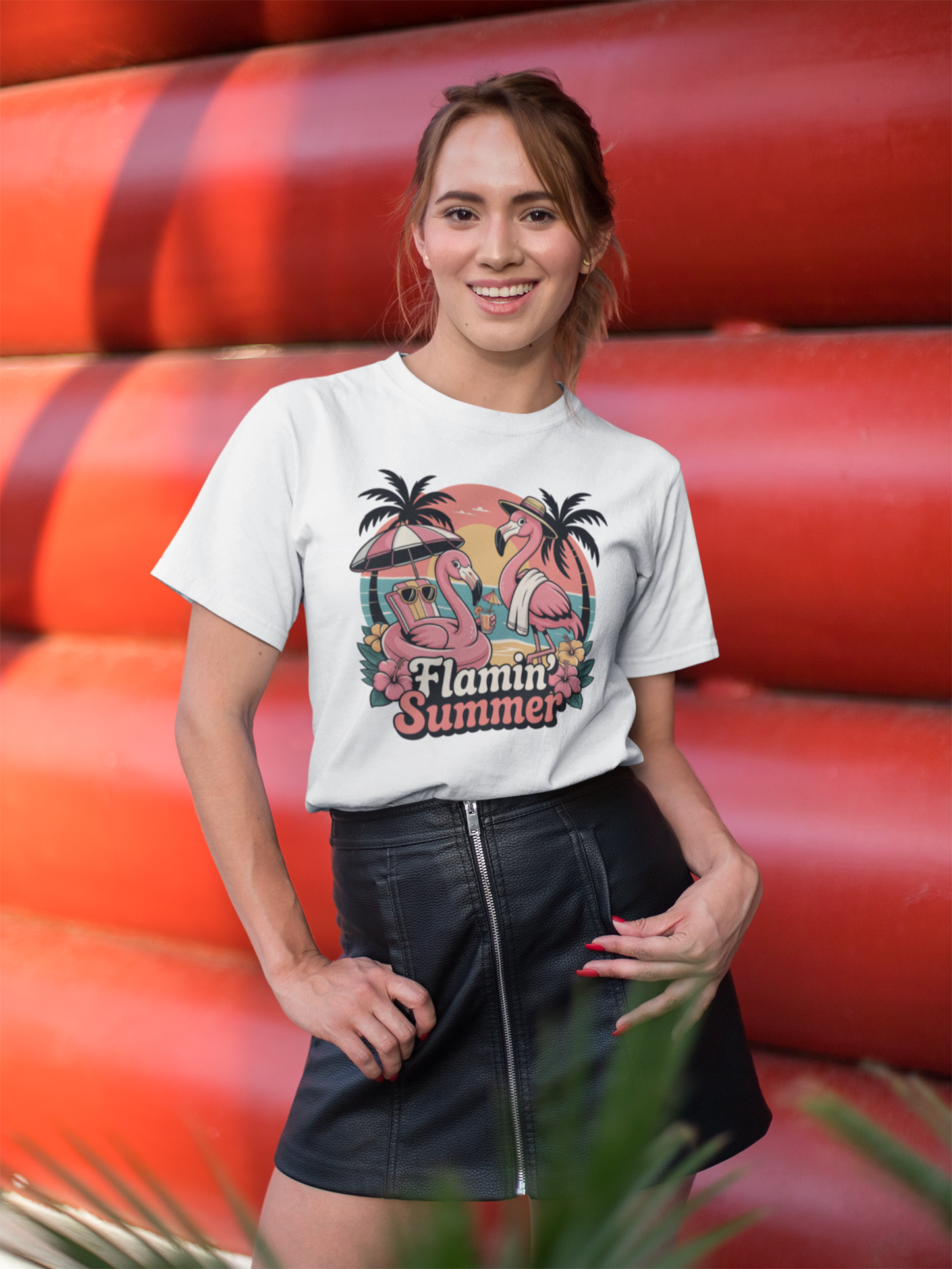 Junge Frau mir schwarzen Minirock in halber Ansicht trägt ein weißes T-Shirt mit Flamingo-Motiv und dem Text „Flamin’ Summer“. Hintergrund rot.