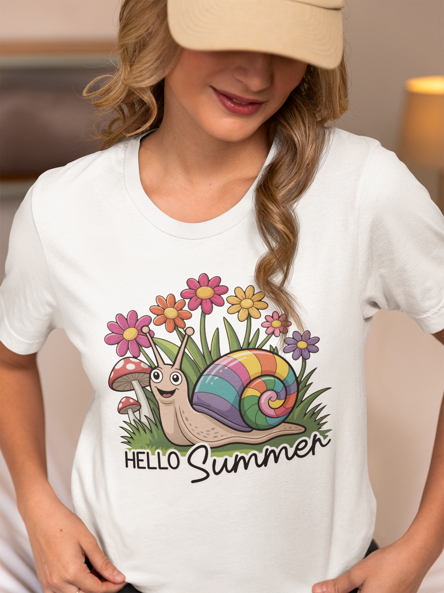 Frau mit Kappe trägt ein weißes T-Shirt mit süßem Comic-Motiv: kleine Schnecke im Blumenbeet, umgeben von Blüten, Text „Hello Summer“