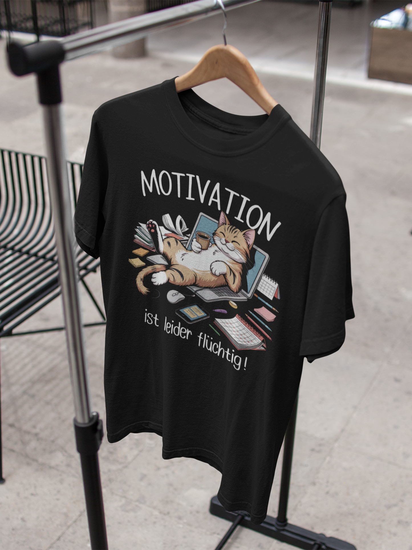 Shirt mit Katzenmotiv auf Kleiderbügel an einem Kleiderständer
