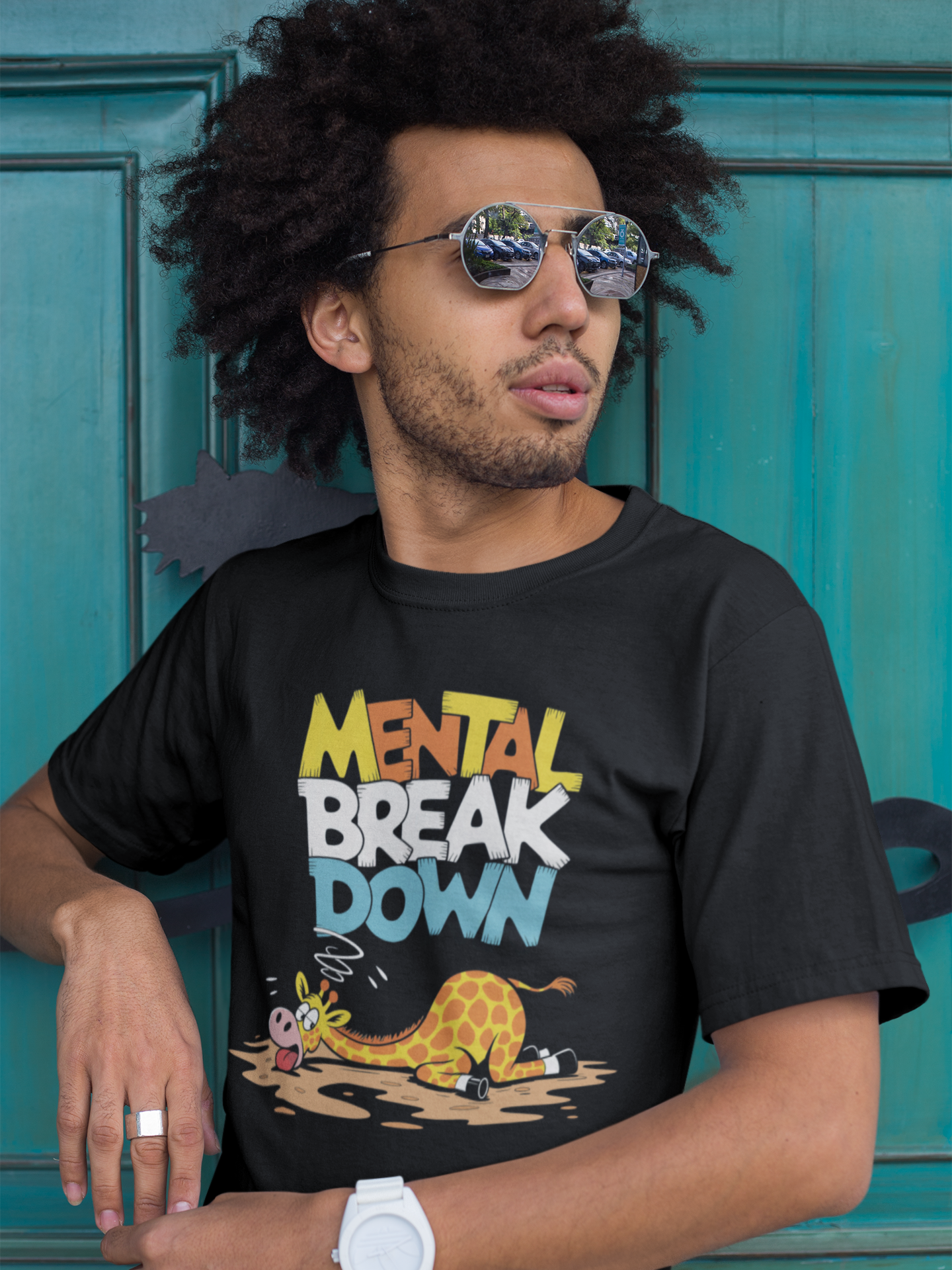 Schwarzer Mann mit Sonnenbrille trägt schwarzes T-Shirt mit Giraffe und dem Spruch „Mental Break Down“ (Oberkörperaufnahme)