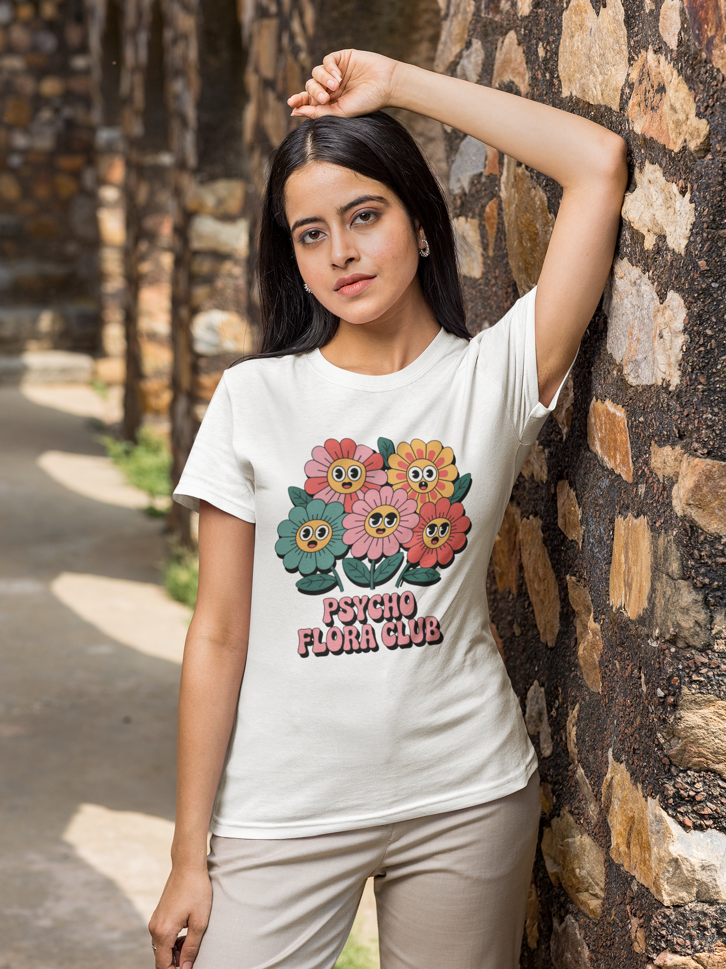 Junge Frau trägt weißess Shirt mit psychedelischen Blumen und „Psycho Flora Club“-Text (Oberkörper)