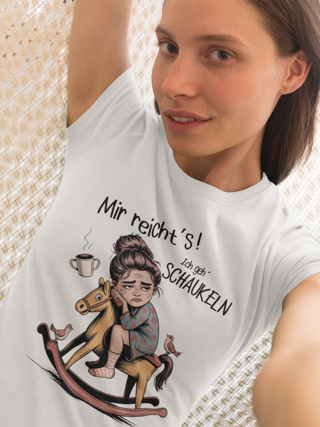 Frau trägt weißes T-Shirt mit dem Text „Mir reichts – Ich geh schaukeln“ und einem Schaukelpferd-Motiv (Oberkörperaufnahme)