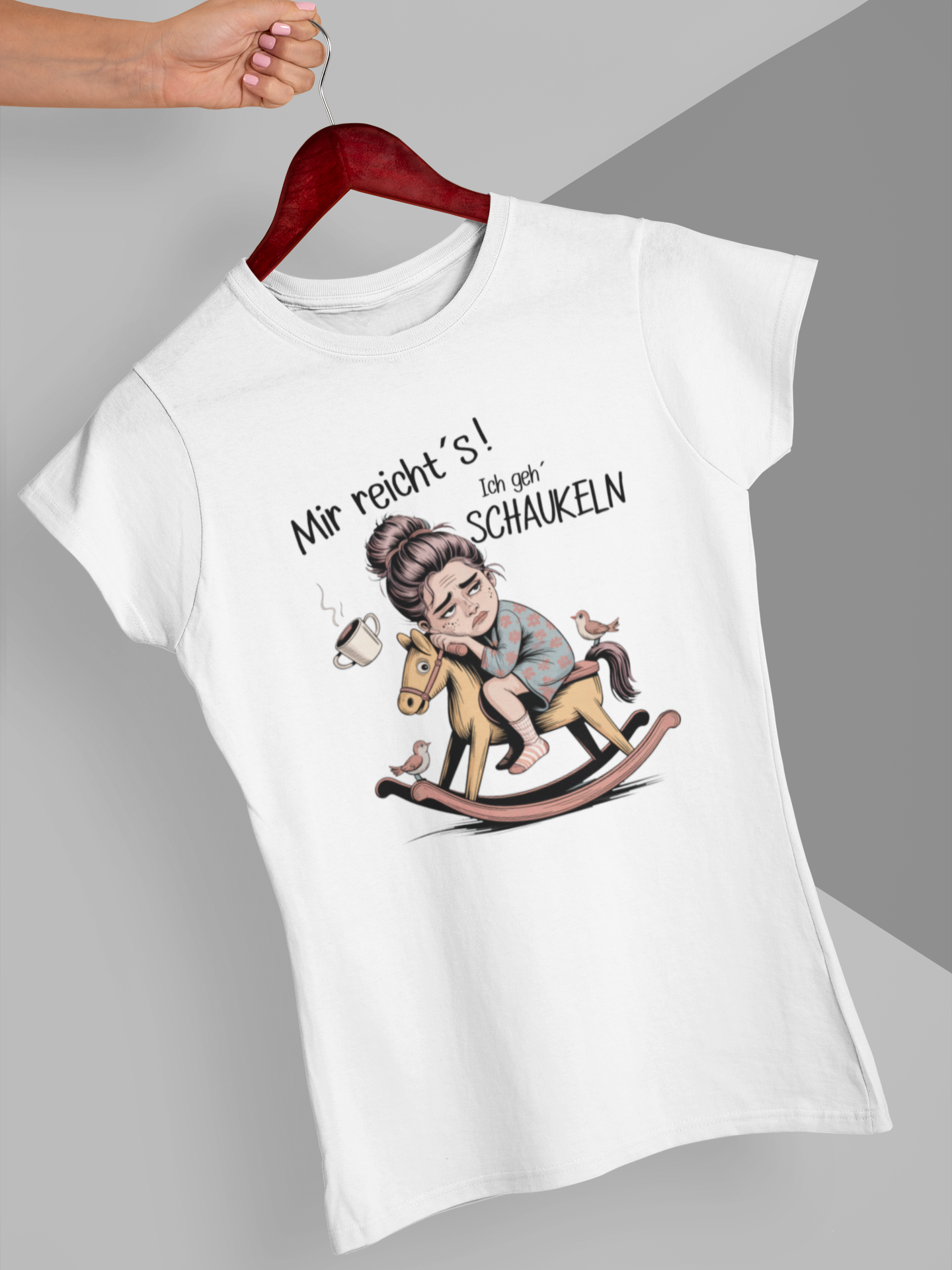 Weißes T-Shirt mit Spruch „Mir reichts – Ich geh schaukeln“ und einem Schaukelpferd-Motiv, auf Kleiderbügel