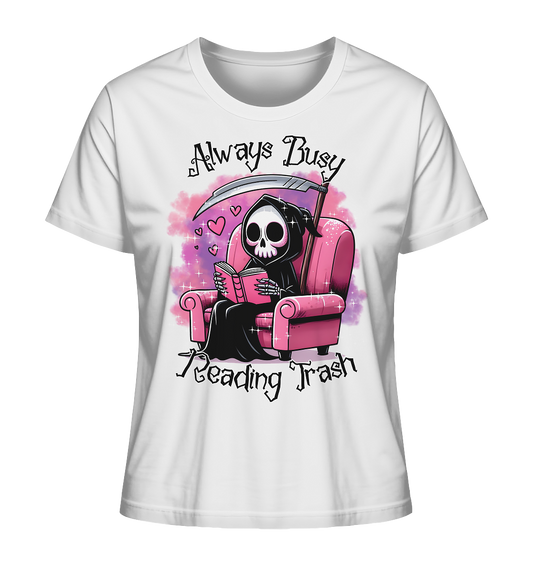 Weißes T-Shirt mit Motiv: Lesender süßer Sensemann auf rosa Sessel. Comic-Stil. Schriftzug: Always Busy Reading Trash.