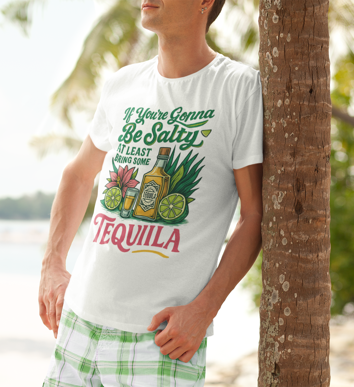 Oberkörper eines Mannes im weißen T-Shirt mit Hibiskusmotiv und Tequila-Spruch, lehnt lässig an einer Palme