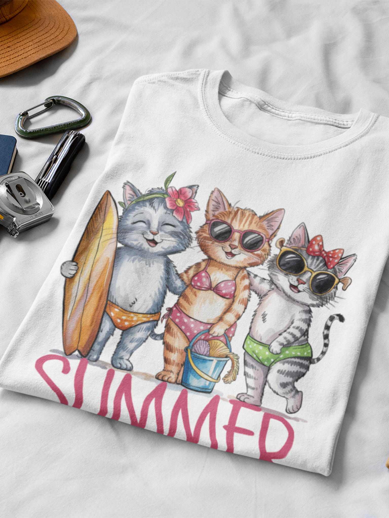 Zusammengefaltetes weißes T-Shirt mit 3 Katzen in Bikini.