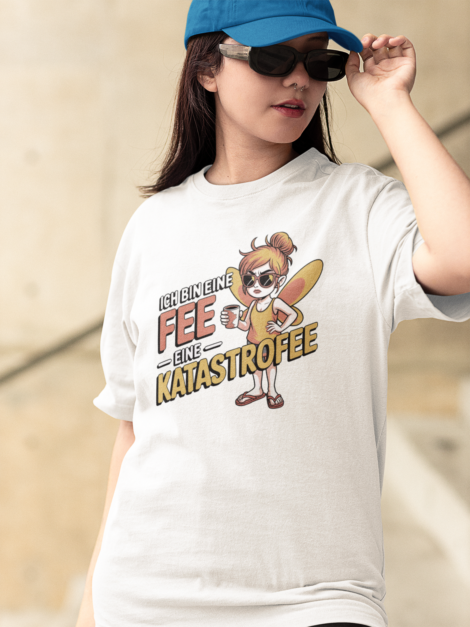 Mädchen mit Sonnebrille trägt ein weißes T-Shirt mit Text: „Ich bin eine Fee. Eine Katastrofee.“