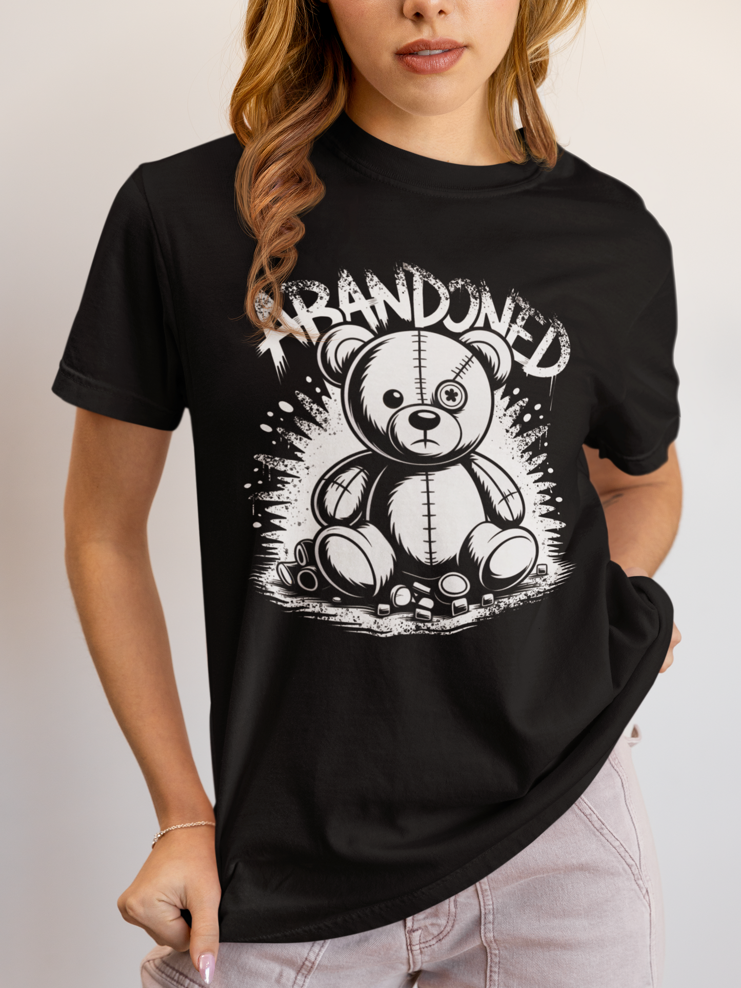 Frau trägt schwarzes T-Shirt mit Abandoned Teddy Graffiti-Motiv (Oberkörperaufnahme)