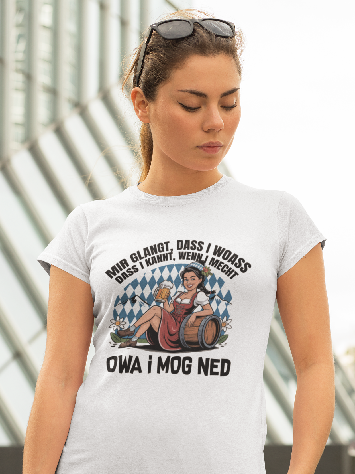 Frau trägt weißes T-Shirt mit Motiv „Owa i mog ned“ und bayrischem Madl (Oberkörper)