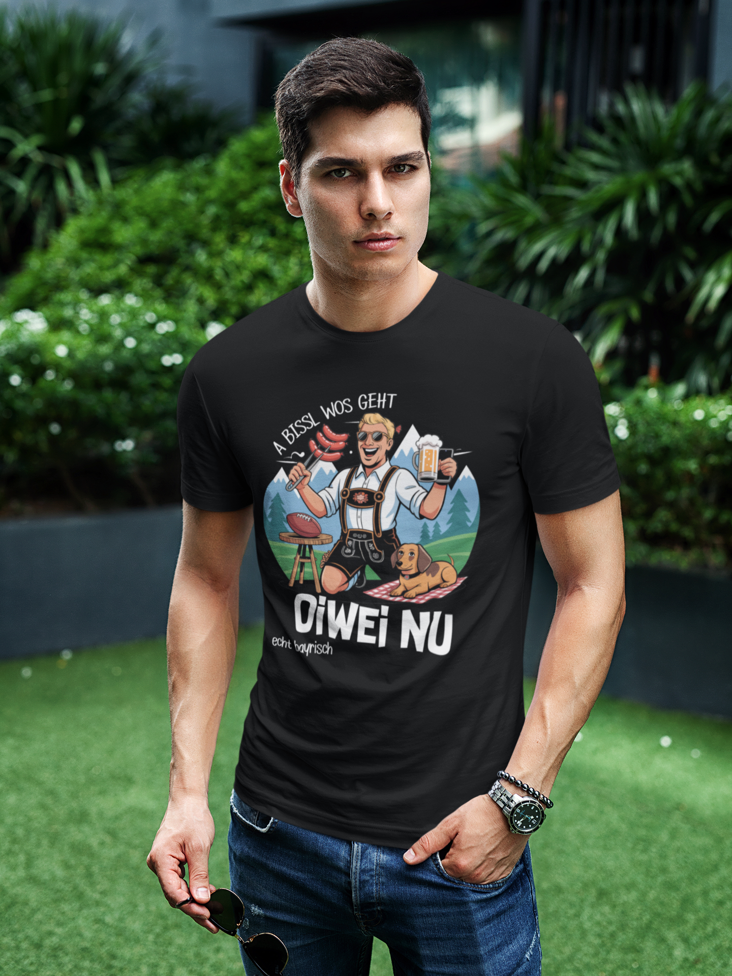 Mann trägt schwarzes T-Shirt mit Spruch „A bissl wos geht oiwei nu“ (Oberkörper)