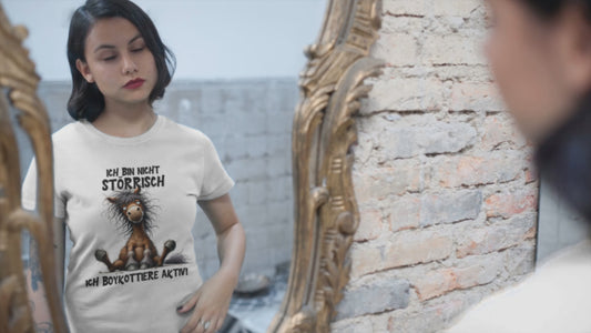 Mödchen vor einem Spiegel,d as sich selbstbewußt durch die Haare streciht. it T-Shirt mit Aufdruck: Ich bin nicht störrisch